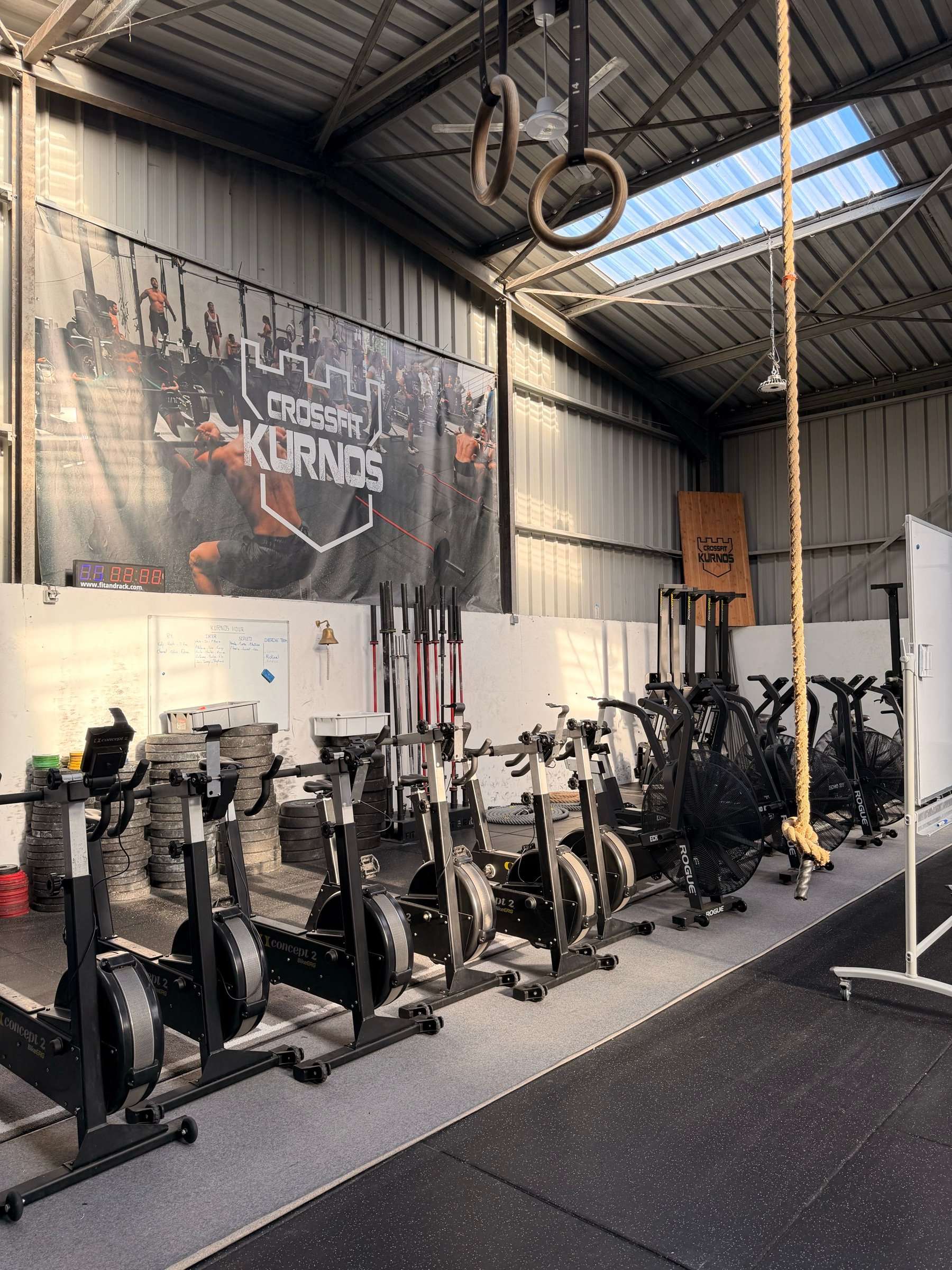 Vélos, anneaux et barres dans la salle CrossFit Kurnos