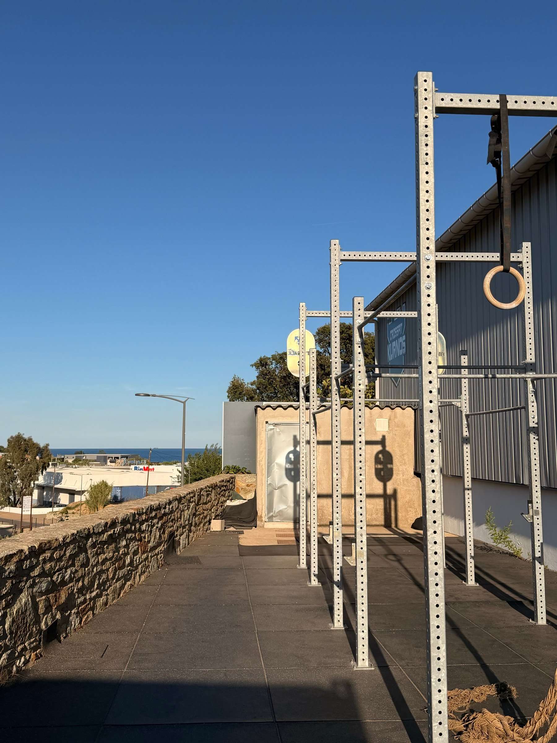 Racks et anneaux sur l’espace extérieur de CrossFit Kurnos, avec vue sur la mer